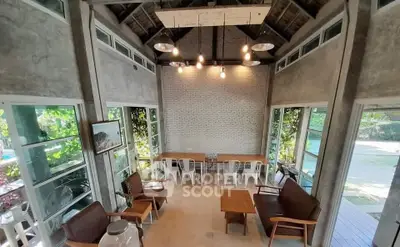 Charming rustic living room with high ceilings and garden view, perfect for relaxation and gatherings.