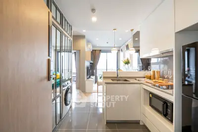 Modern open-layout kitchen with sleek appliances and bright living area view.