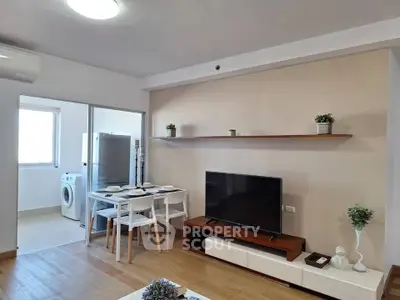 Modern living room with dining area and washing machine in open layout apartment.