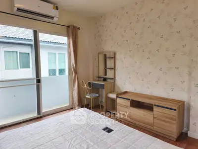 Bright bedroom with balcony access and modern furniture in a cozy home.