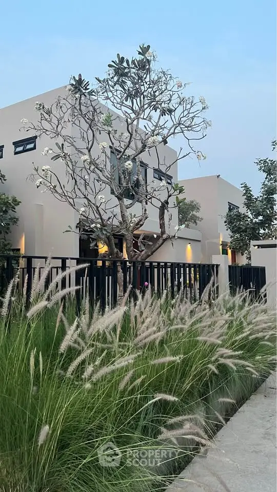 Modern architectural home with lush landscaping and elegant exterior design.