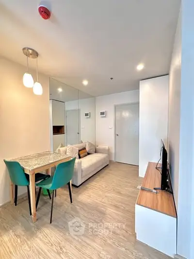 Modern living room with stylish decor, cozy sofa, and dining area in a bright apartment.