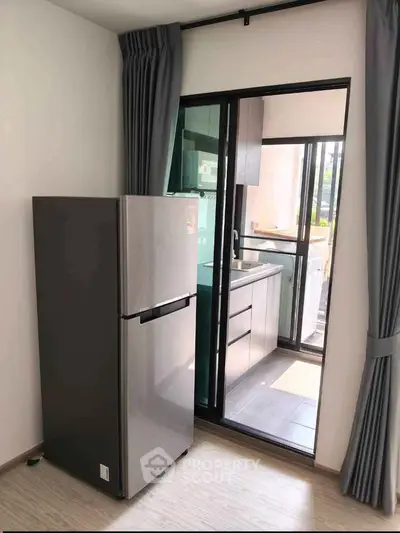 Modern kitchen with sleek refrigerator and balcony view, perfect for urban living.