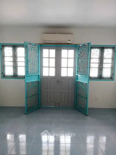 Spacious room with elegant turquoise window grills and air conditioning, perfect for modern living.