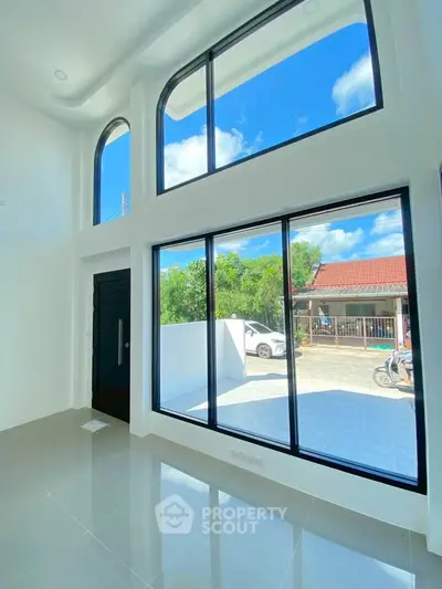 Stunning modern living room with high ceilings and large windows offering abundant natural light.