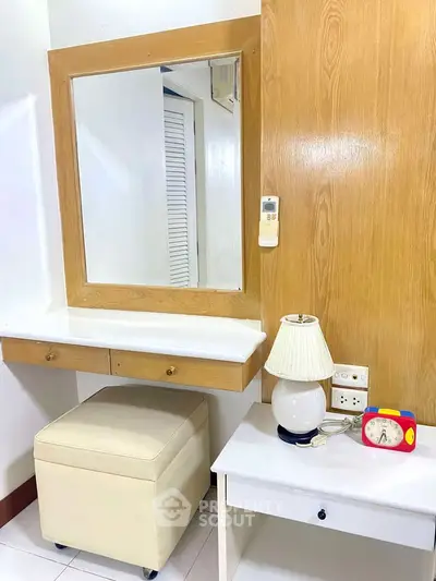 Cozy bedroom corner with vanity mirror, lamp, and modern decor
