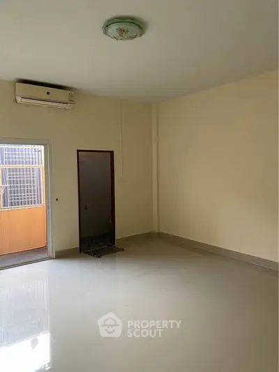 Spacious unfurnished room with air conditioning and balcony access, ideal for customization.