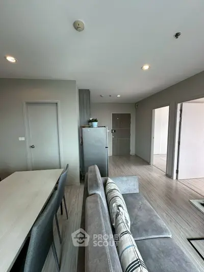 Modern living room with sleek furniture and open layout, featuring a stylish dining area and neutral color palette.