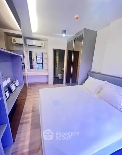 Modern bedroom with sleek design and ample storage in a contemporary apartment.