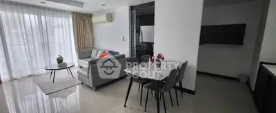 Spacious modern living room with elegant dining area and large windows for natural light.
