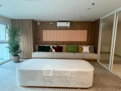 Modern living room with stylish sofa and colorful cushions, featuring a minimalist design and natural light.