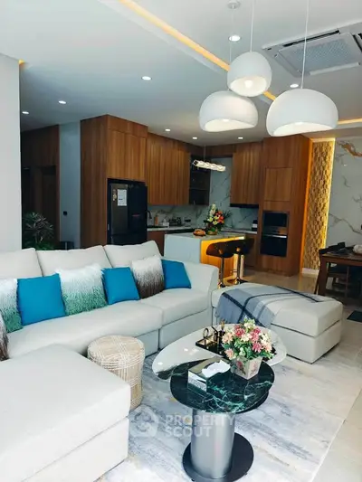Luxurious modern living room with open kitchen, stylish decor, and cozy seating area in a contemporary apartment.
