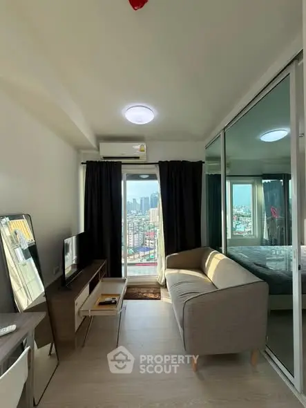 Modern living room with city view, featuring sleek furniture and large windows for natural light.