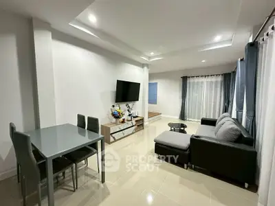 Modern living room with sleek furniture and large TV, ideal for relaxation and entertainment.