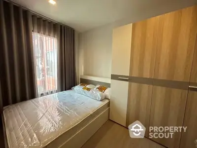 Cozy bedroom with large window and modern wooden wardrobe, featuring a comfortable bed and elegant interior design, ideal for relaxation and privacy.