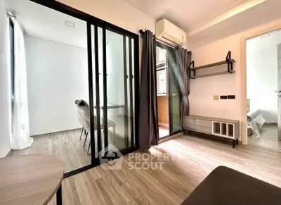 Modern apartment interior with sliding glass doors and stylish furnishings, featuring a cozy living area and natural light.