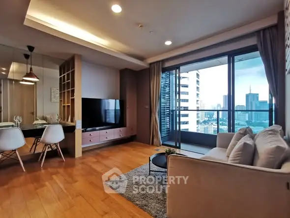 Modern living room with city view and large balcony in luxury apartment.