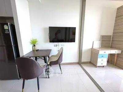 Modern living room with sleek furniture and wall-mounted TV in a stylish apartment.