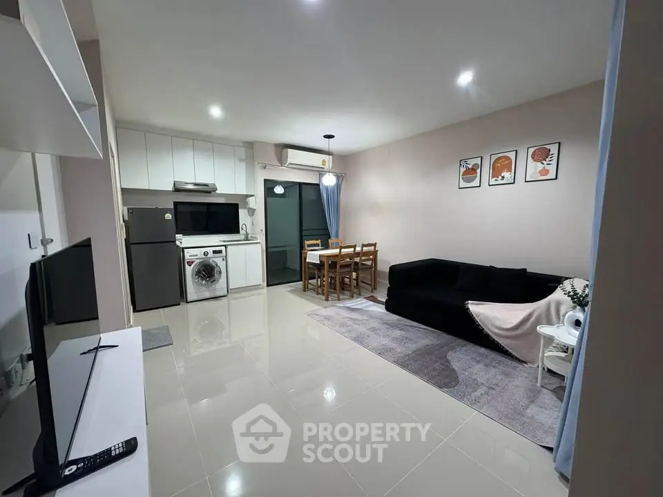 Modern open-plan living room with kitchen, dining area, and cozy seating.