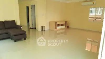 Spacious living room with modern sofa and air conditioning, ideal for comfortable living.