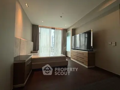 Spacious modern bedroom with large window and sleek furniture in luxury apartment.