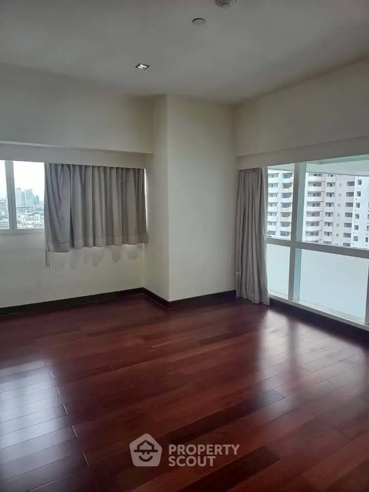 Spacious corner unit with hardwood floors and large windows offering city views.