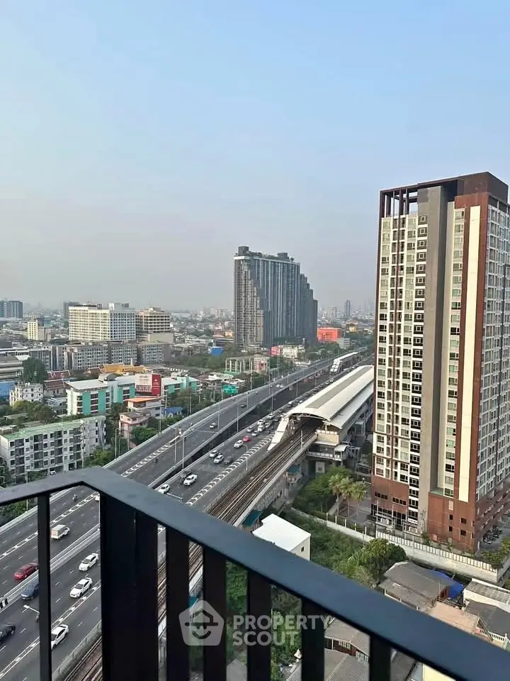 Stunning cityscape view from a high-rise balcony overlooking urban skyline and transportation hub.
