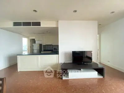 Spacious open-plan living area with modern kitchen and TV setup, perfect for entertaining.