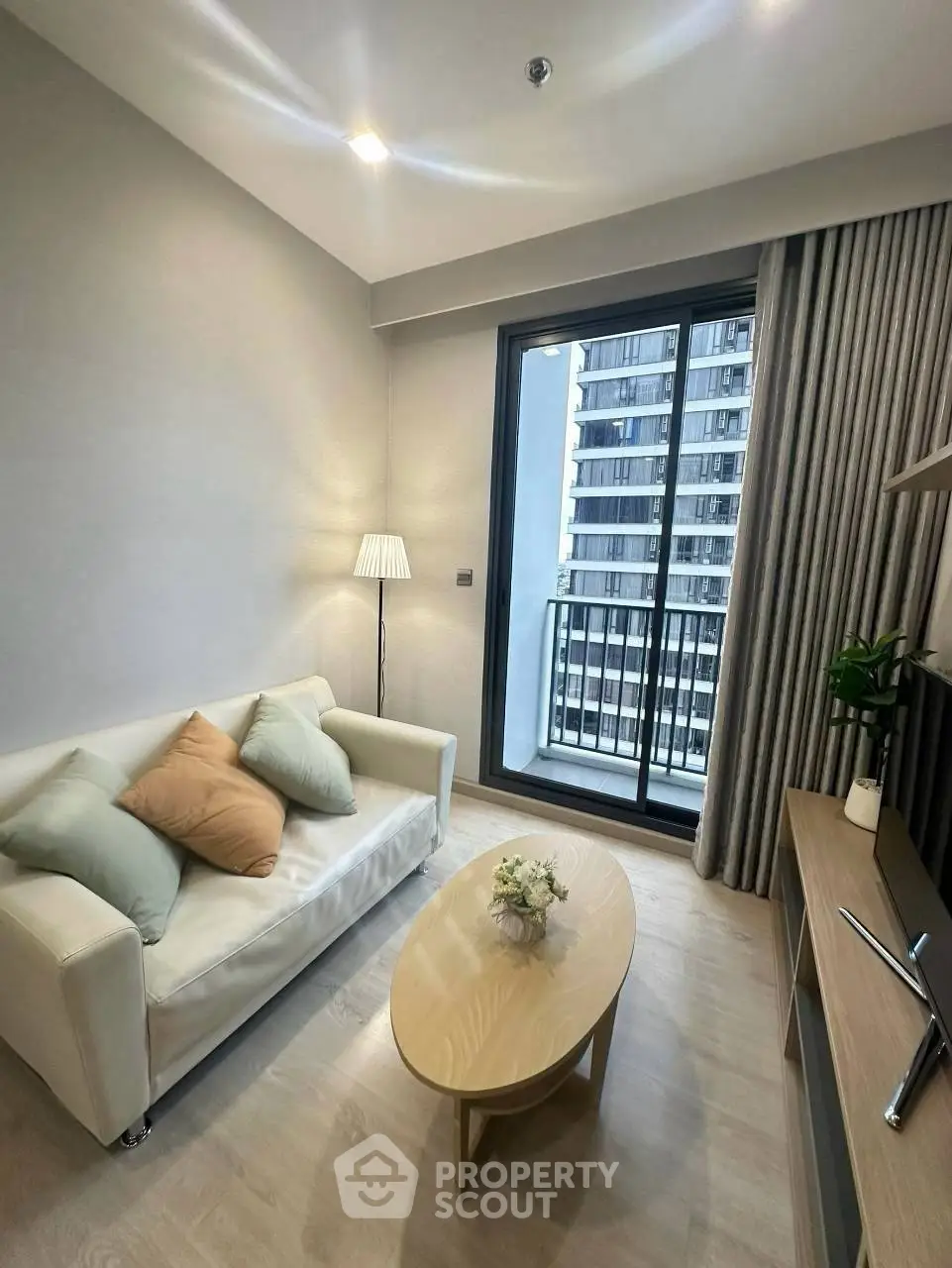 Modern living room with cozy sofa and balcony view in stylish apartment