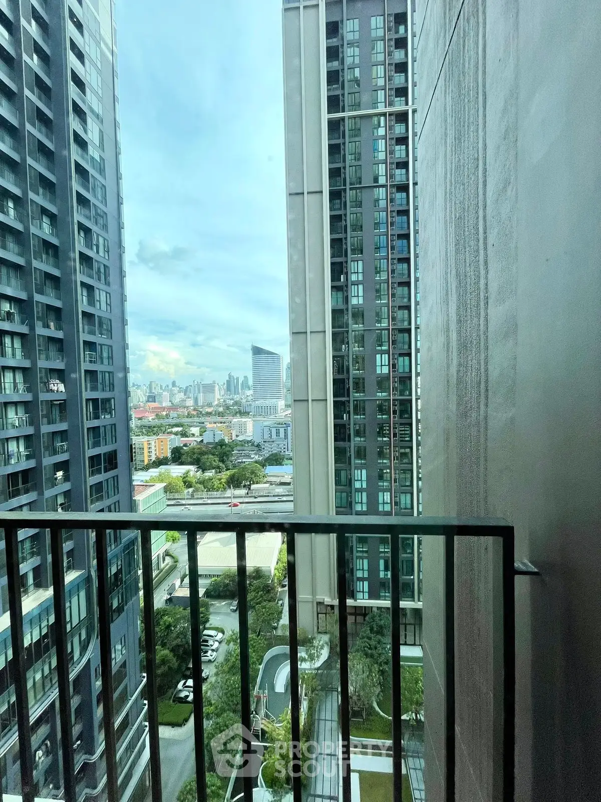 Stunning urban view from a high-rise balcony overlooking city skyline and modern architecture.