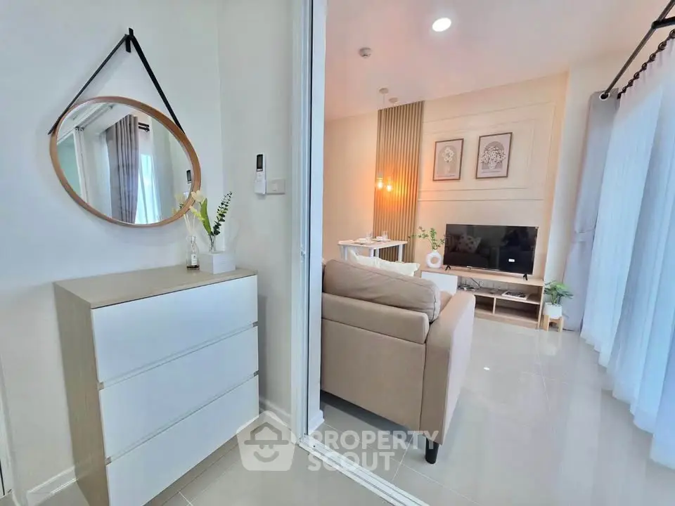 Modern living room with stylish decor and natural light, featuring a cozy sofa and wall-mounted TV.