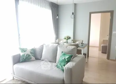 Bright and modern living room with stylish decor and dining area in open layout apartment.