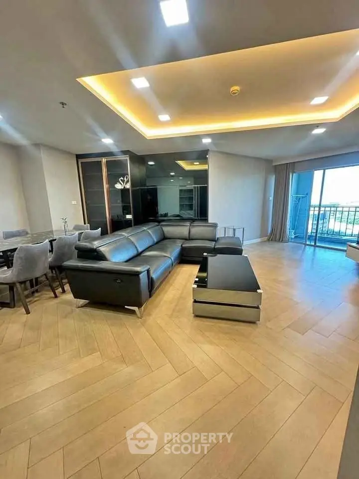 Spacious modern living room with elegant lighting and large balcony access.