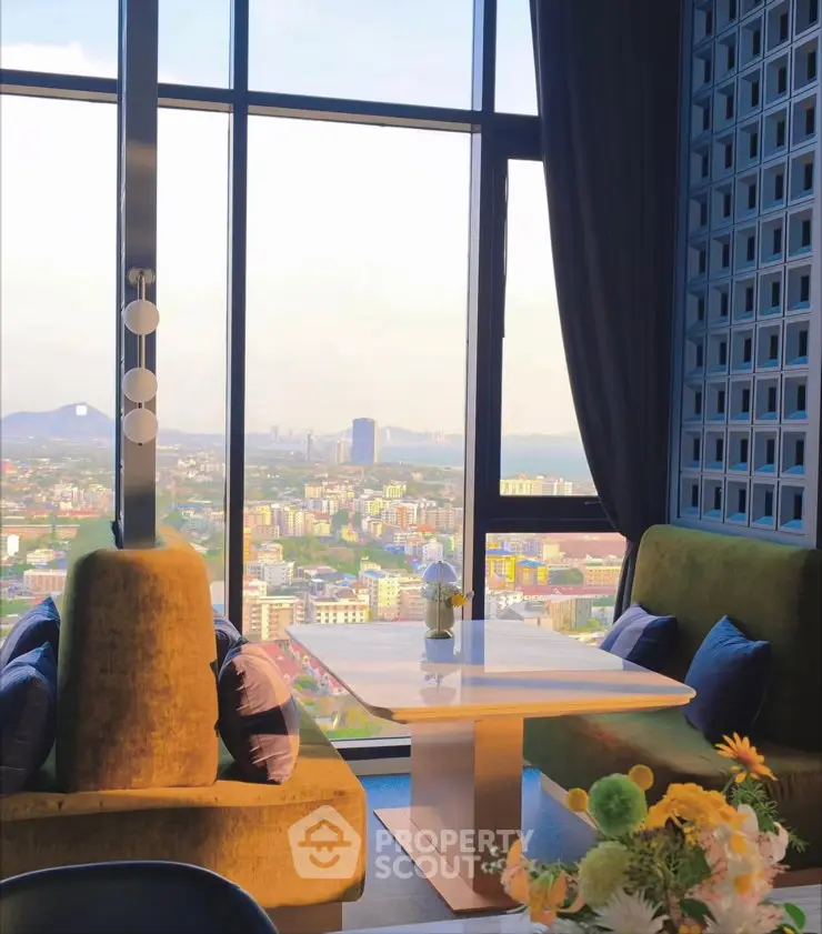 Luxurious high-rise living room with panoramic city view and elegant decor.