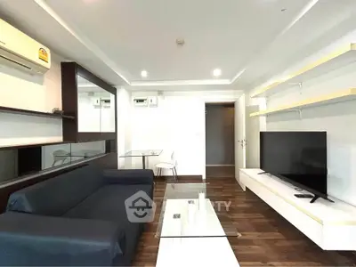 Modern living room with sleek furniture and mounted TV in a stylish apartment.