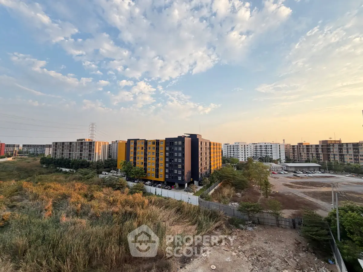 Stunning view of modern apartment complex with expansive greenery and clear sky.