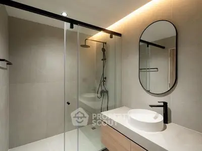 Modern bathroom with sleek shower and stylish vanity in contemporary apartment.