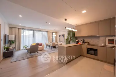 Spacious open-plan living room and kitchen with modern decor and natural light.