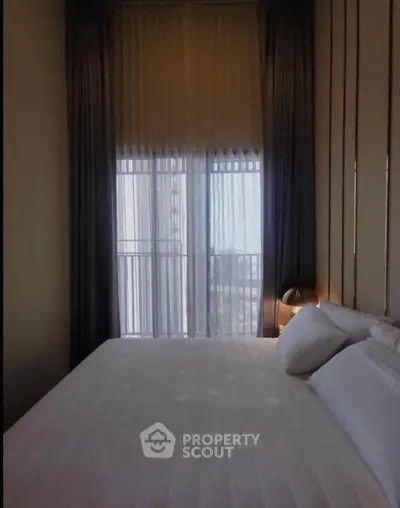 Cozy bedroom with elegant curtains and soft lighting, offering a serene ambiance for relaxation.