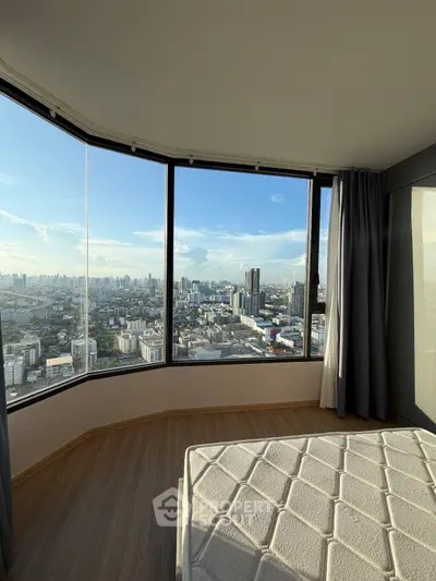 Stunning bedroom with panoramic city view from floor-to-ceiling windows, showcasing modern urban living.
