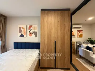 Modern bedroom with stylish decor and wooden wardrobe, featuring a cozy bed and contemporary artwork.