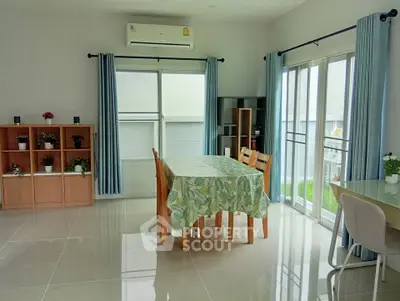 Bright dining area with modern furniture and large windows in a stylish home.