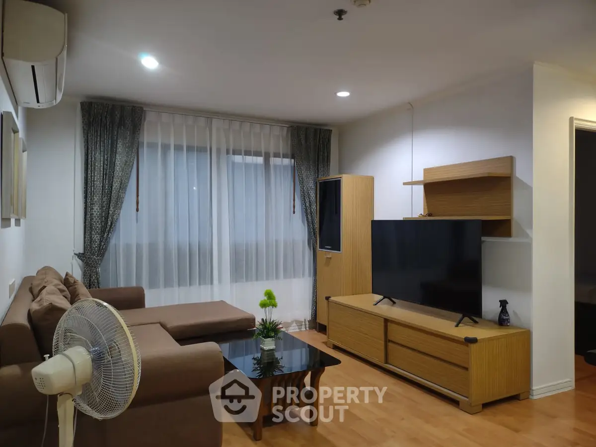 Spacious living room with modern furniture and large TV, perfect for relaxation.