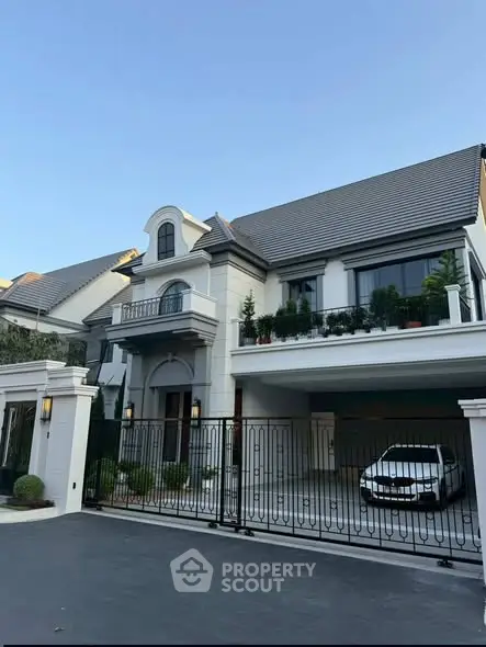 Luxurious modern house with elegant facade and spacious driveway in upscale neighborhood.