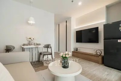 Modern living room with sleek decor and wall-mounted TV in stylish apartment.
