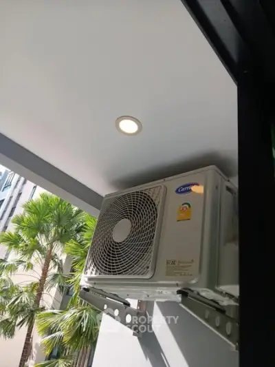 Modern balcony with air conditioning unit and view of palm trees