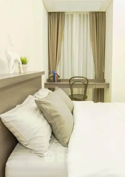 Cozy bedroom with elegant decor and natural light, featuring a stylish desk and chair by the window.