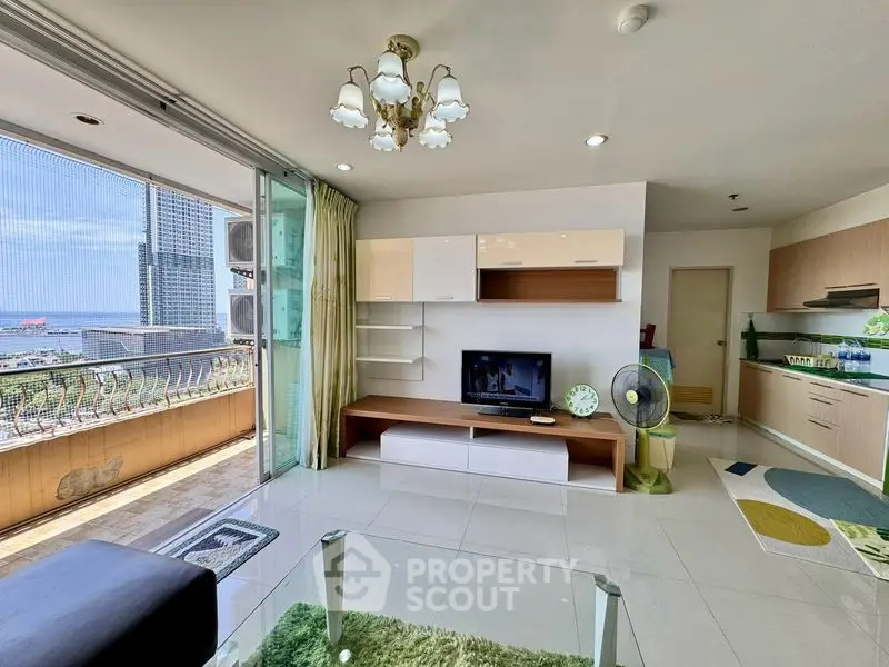Spacious living room with modern decor and stunning balcony view in a high-rise apartment.