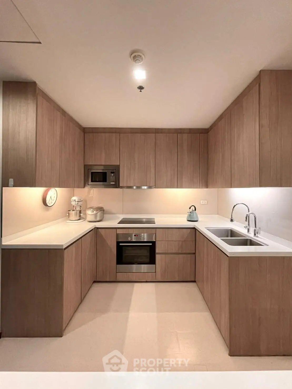 Modern kitchen with sleek wooden cabinetry and built-in appliances in a stylish apartment.