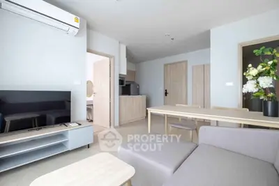 Modern living room with sleek furniture and open layout, featuring air conditioning and stylish decor.